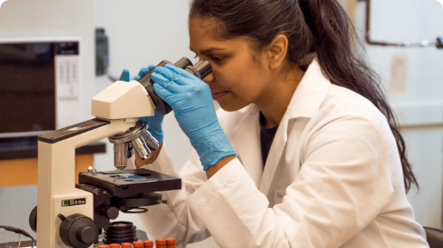 A researcher looking through a microscope