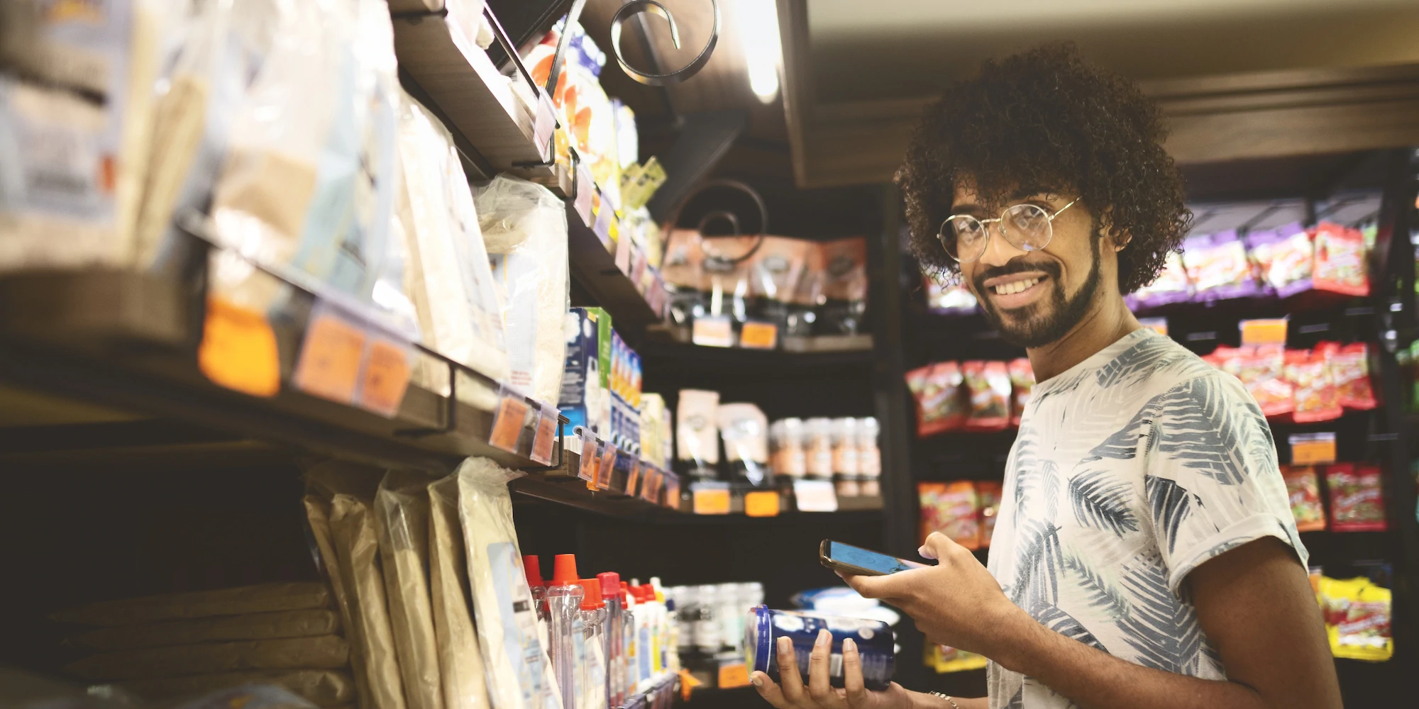 Young black man purchasing a drink at a small store