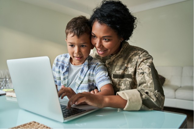Military mother on computer with child.