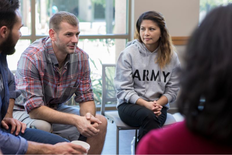 Mid adult veterans discusses war experiences during a support group meeting for veterans.