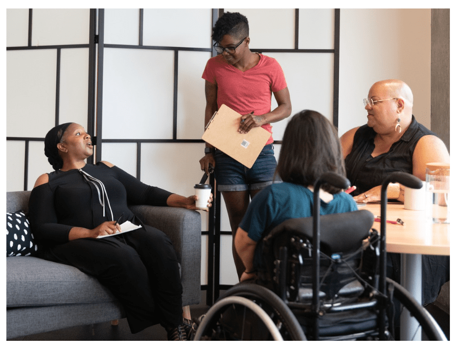 A group of people with and without disabilities in a training session.