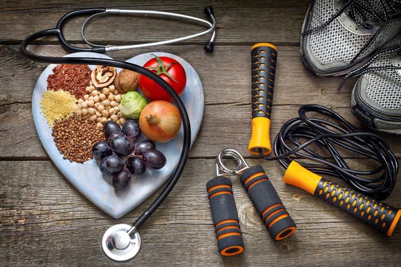 Healthy foods displayed on table, along with a jump rope and running shoes