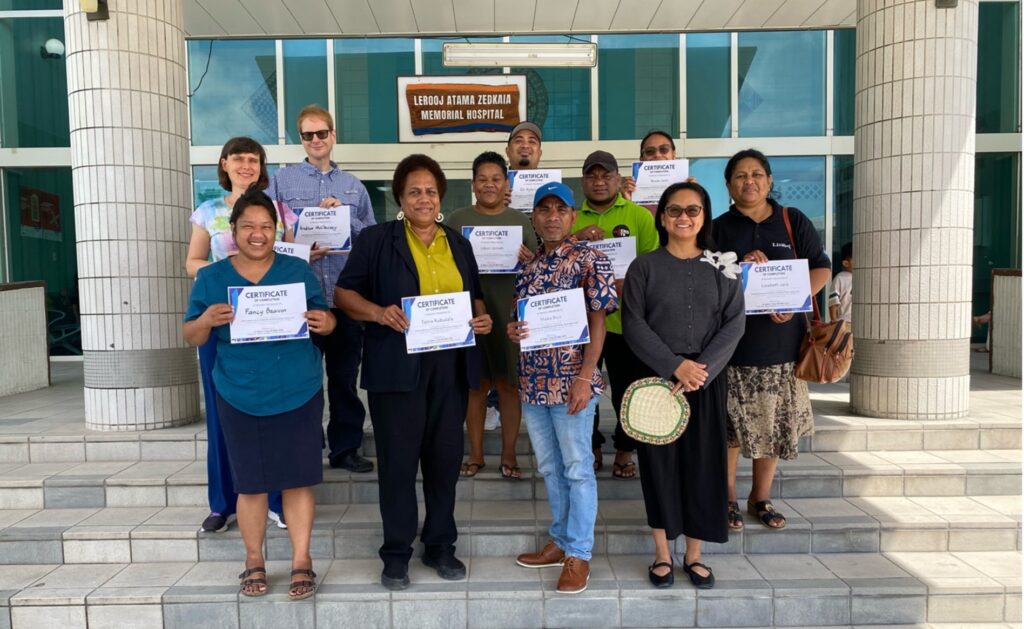 a group of people hold certificates and pose for the camera