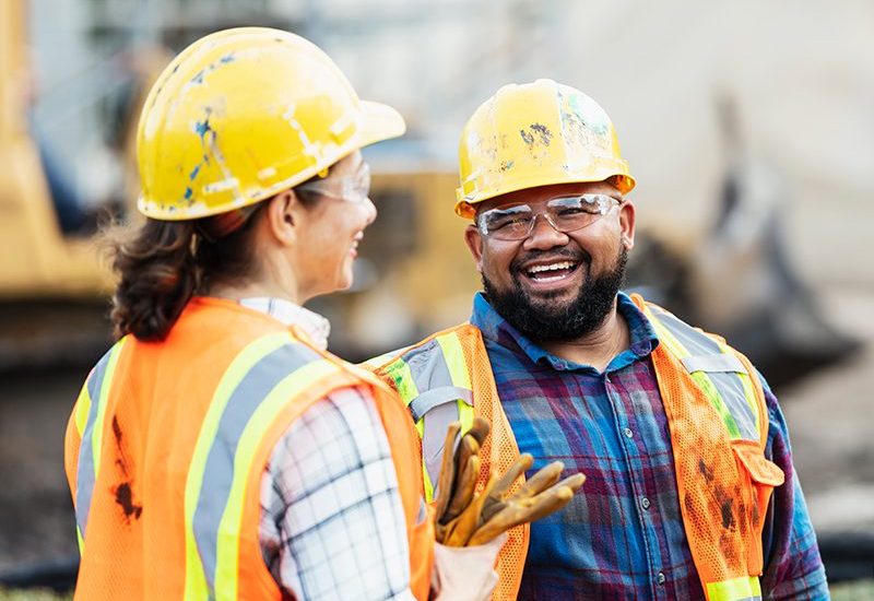 Two construction workers smiling on the job.